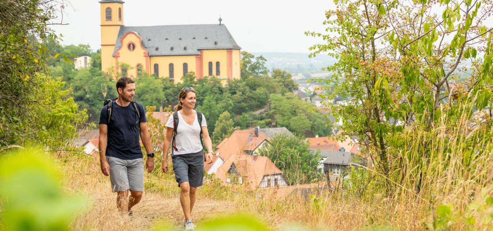 Wanderpaar mit Blick auf die Kirche St. Gereon von Nackenheim, © Dominik Ketz Wanderpaar mit Blick auf die Kirche St. Gereon von Nackenheim, © Dominik Ketz