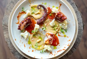 Fine-Dining-Gericht mit gegrilltem Oktopus, cremigem P&uuml;ree, Blumenkohl und Kr&auml;utern &ndash; moderne Gourmetk&uuml;che.