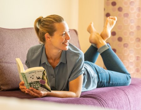 Weingut Meyerhof Frau im Hotelzimmer lesend, © Dominik Ketz