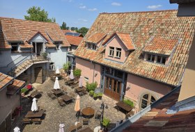 Historischer Kulturhof Eckelsheim mit sonnigem Innenhof, Sitzgelegenheiten und mediterranem Flair.