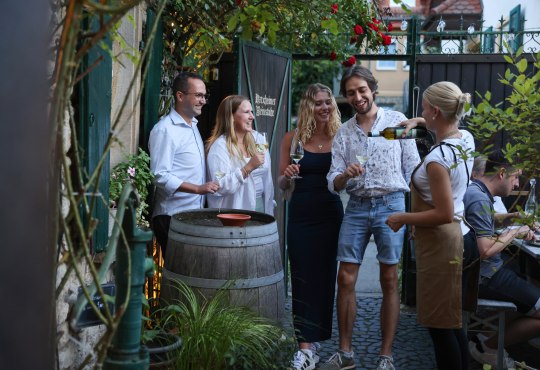 Geselliges Beisammensein beim Weinhöfefest in Harxheim – Freunde genießen Wein im idyllischen Hofambiente