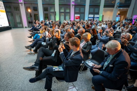 Publikum mit Handys in der Hand fotografieren die Bühne