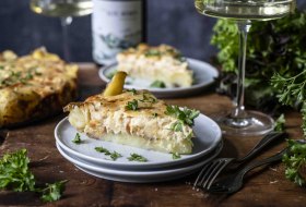 Zwiebelkuchen mit Quetschkartoffeln mit frischen Kräutern, serviert mit Weißwein – regionaler Genuss aus Rheinhessen.