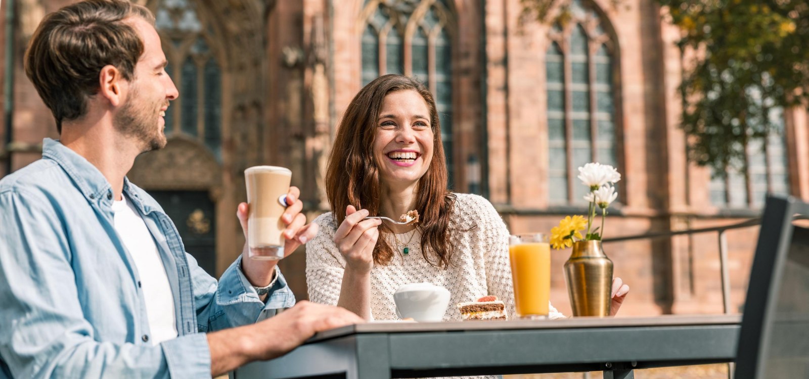 A couple is drinking in front of the Cathedral in Worms.