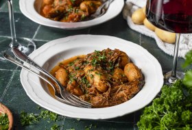 Rinderschmortopf mit Kurbis und Kartoffel angerichtet in einem Suppenteller