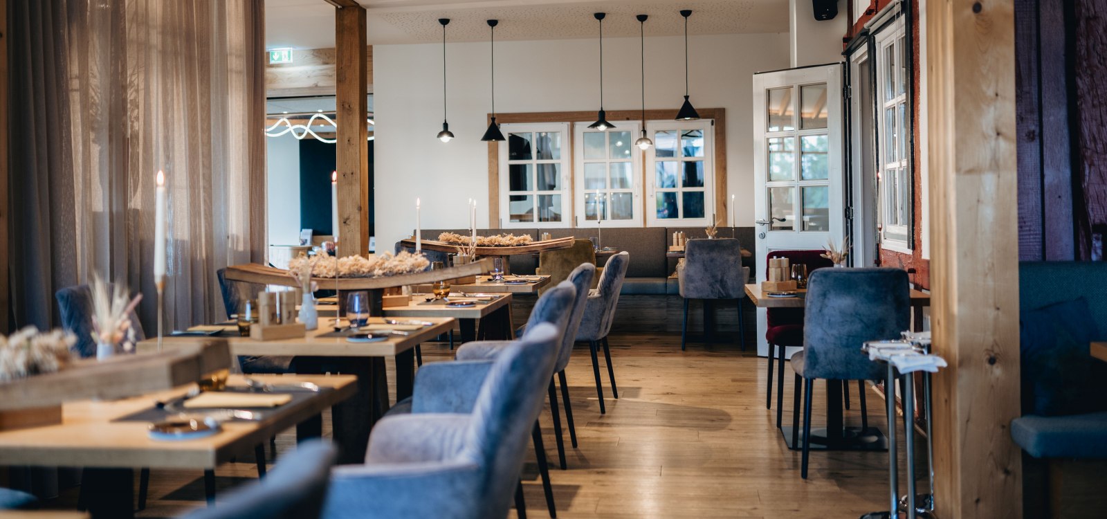 Modernes Restaurant mit stilvoll gedeckten Tischen, Kerzenlicht und gem&uuml;tlichem Ambiente.