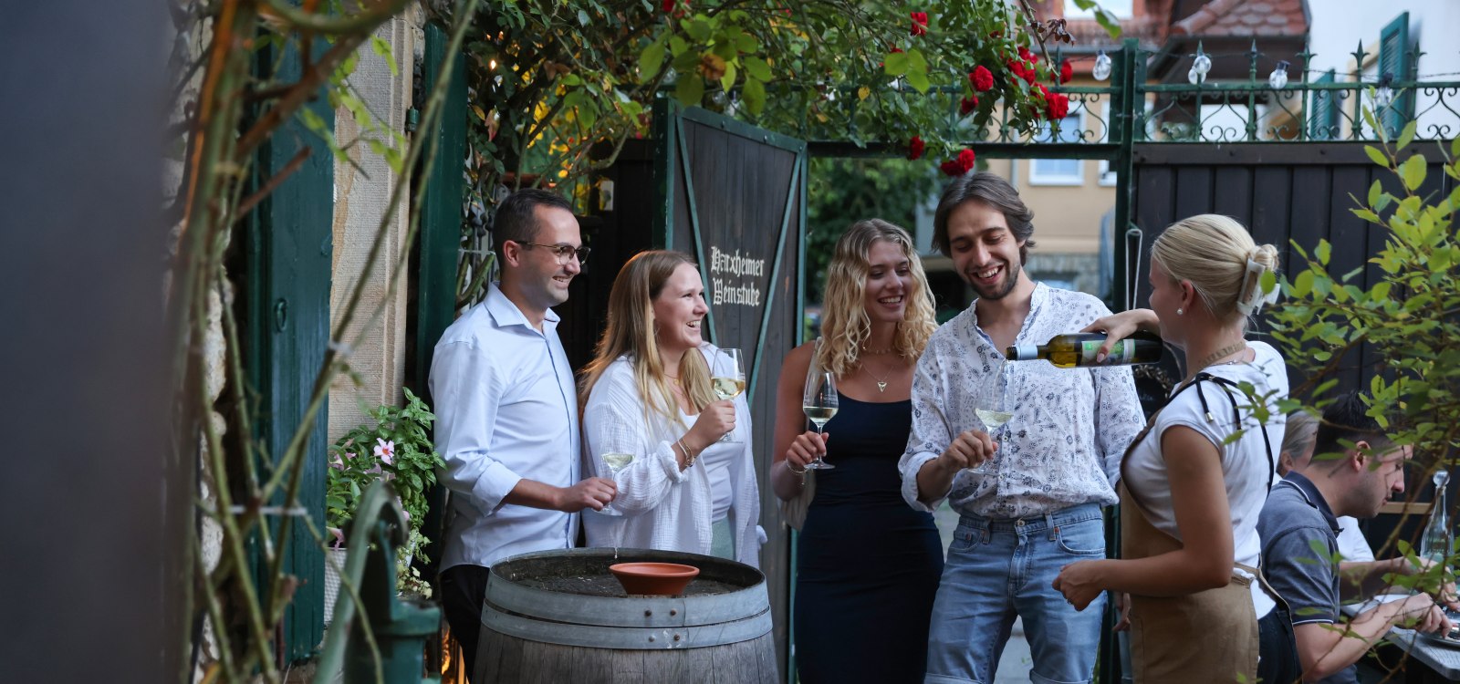 Geselliges Beisammensein beim Weinhöfefest in Harxheim – Freunde genießen Wein im idyllischen Hofambiente